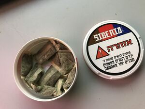 A can of Siberia Snus, showing the contained pouches and container lid